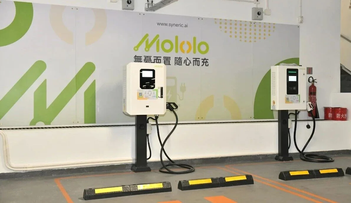 Two Mololo charging stations on black pedestals in an indoor car park beneath the Mololo wall sign